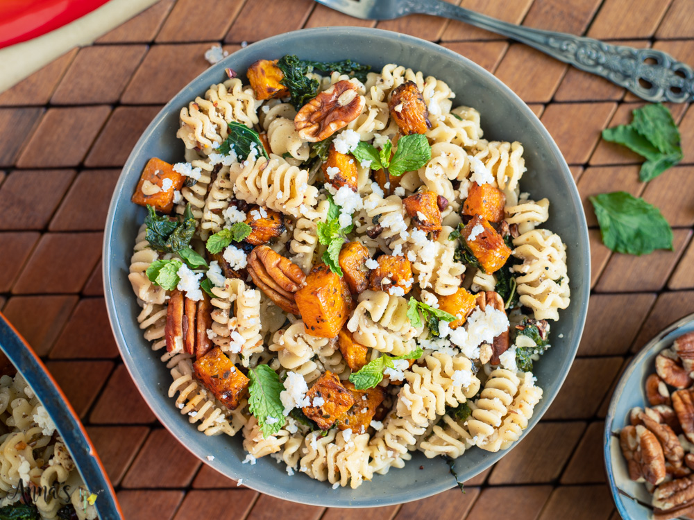 bowl of pasta and butternut squash with ricotta sauce and walnuts and mint on top